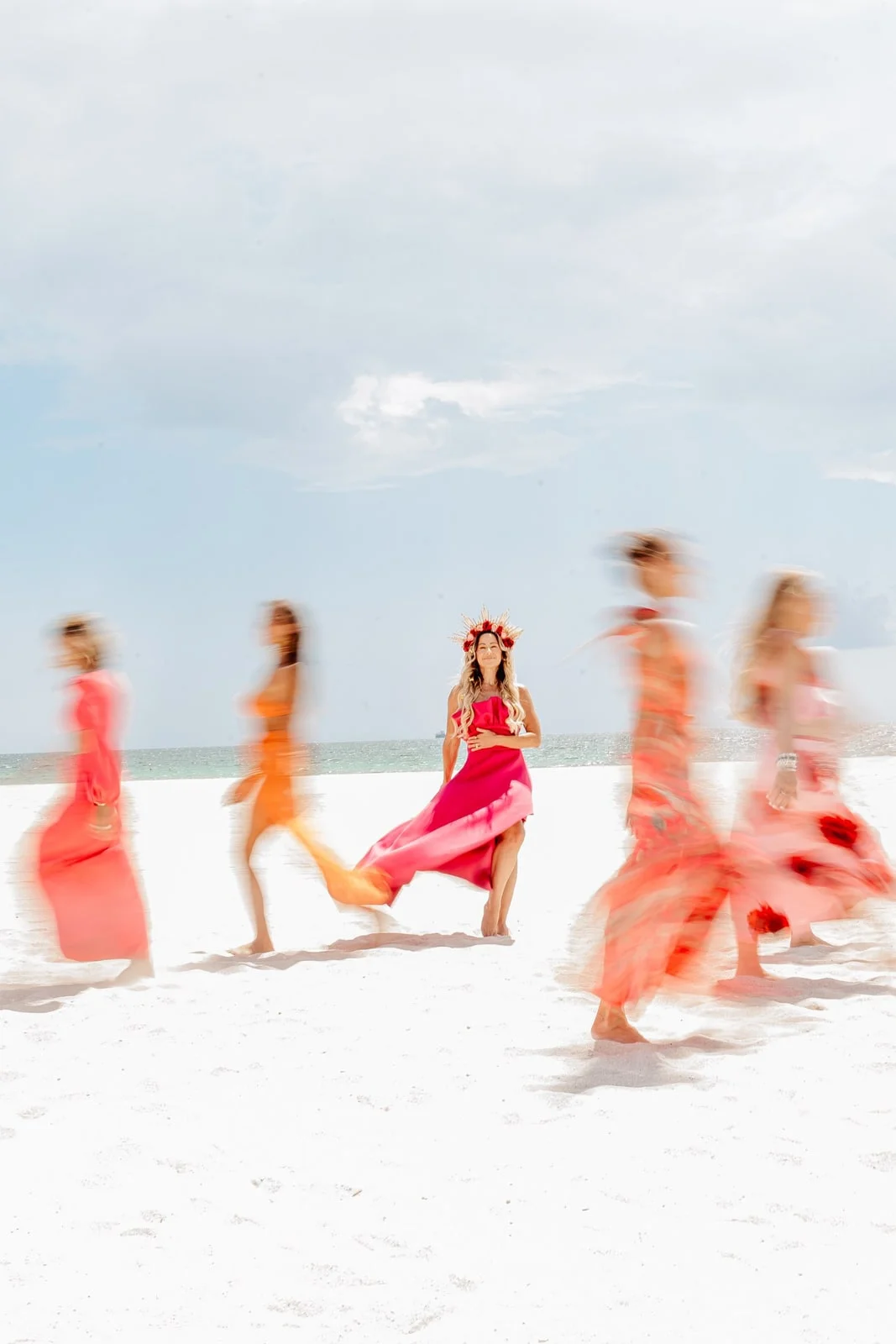 Women dancing on the beach, dresses in motion