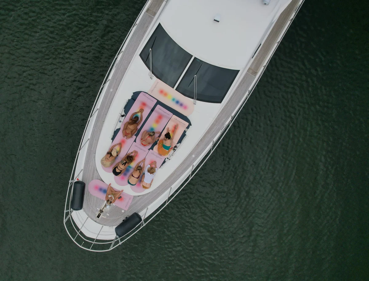 Overhead drone view of Starseed Summit guests on Aura Therapy mats across the bow of the yacht
