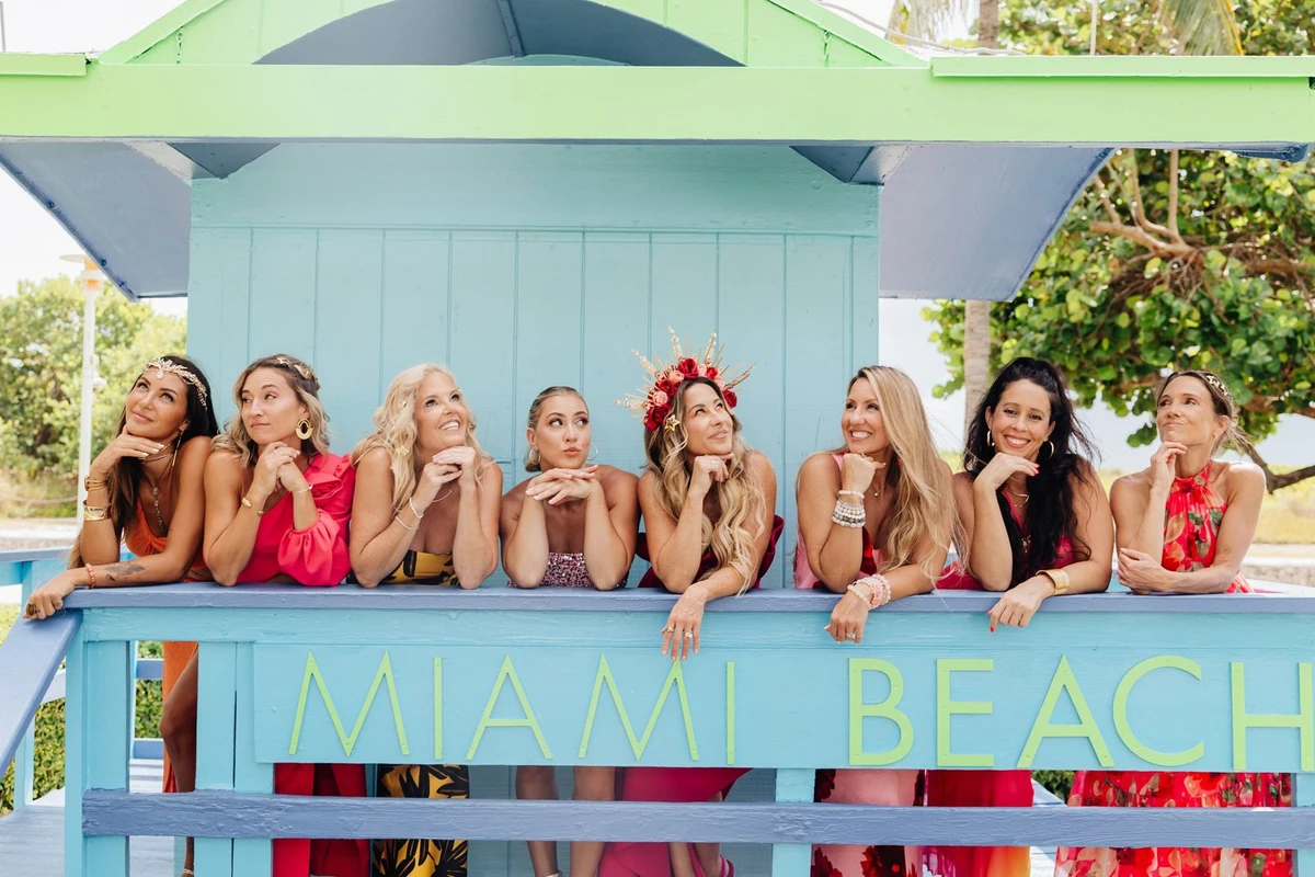 Starseed Summit guests leaning along the rail of a painted Miami Beach lifeguard stand